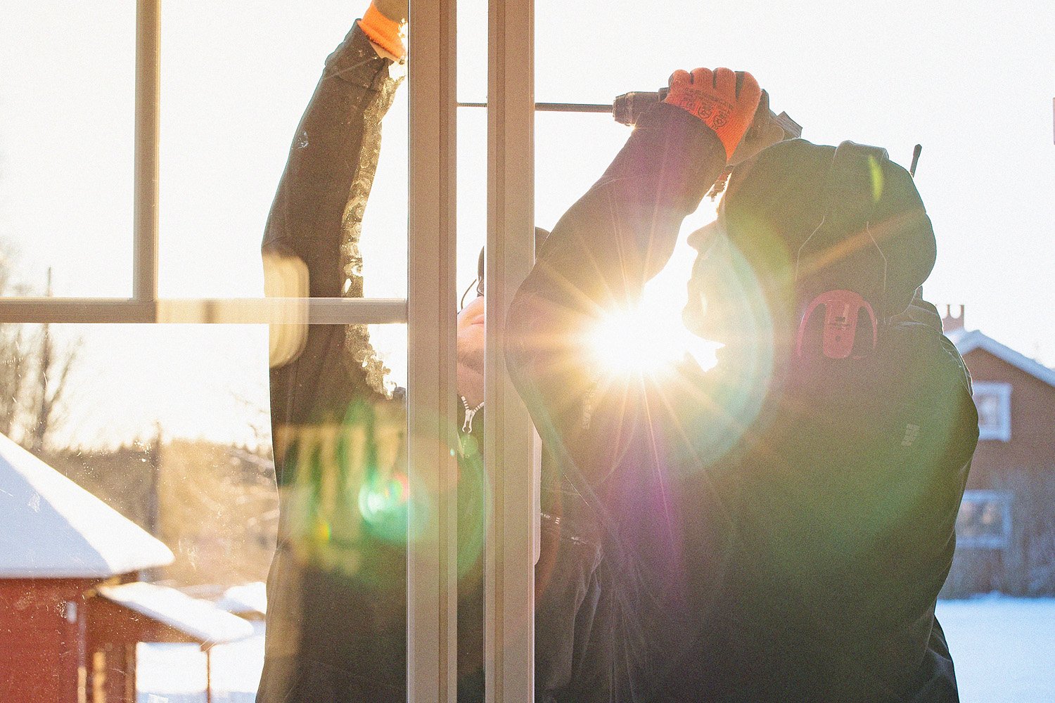 Montör installerar fönster i hus under vintertid.
