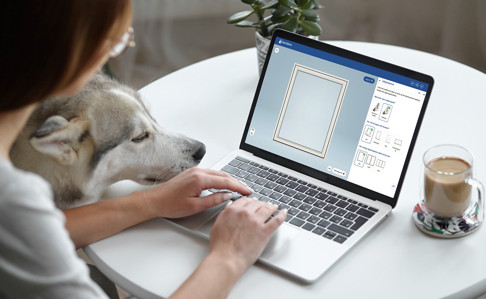 Person använder laptop för att konfigurera fönster, med hund bredvid.